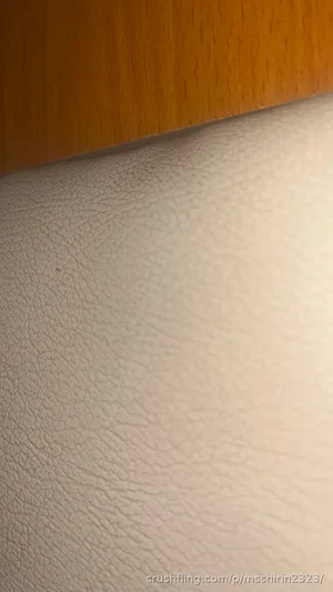Close-up of textured white surface and wooden edge, no person visible.