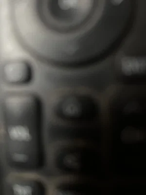 Blurry close-up of black remote control buttons.