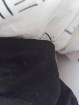 Black fabric on white textured surface.