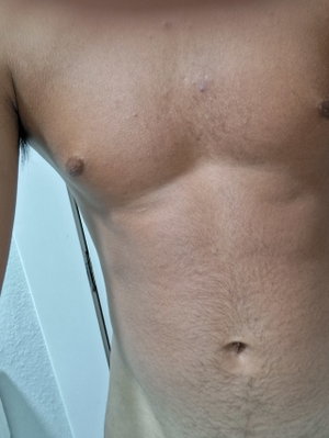 Shirtless man with toned torso and visible chest hair in indoor setting.