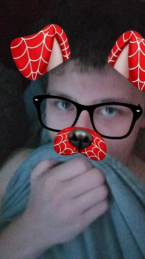 Person with Spider-Man filter covering face, holding gray blanket, indoors.