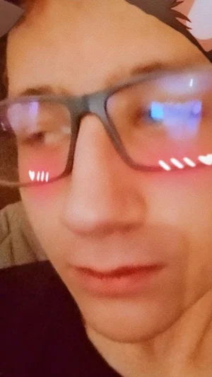 Close-up of a person with glasses and a digital filter, indoors.