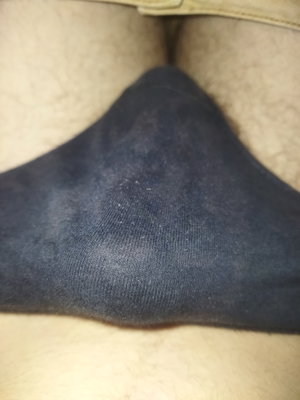 Close-up of dark clothing on light surface.