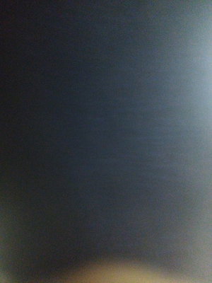 Dark blurry image with faint light at bottom.