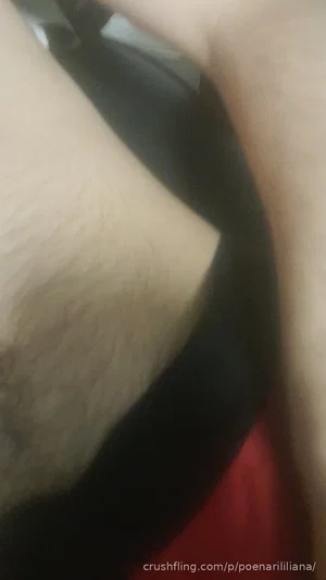 Close-up of a person's arm with visible hair, wearing a black and red garment.