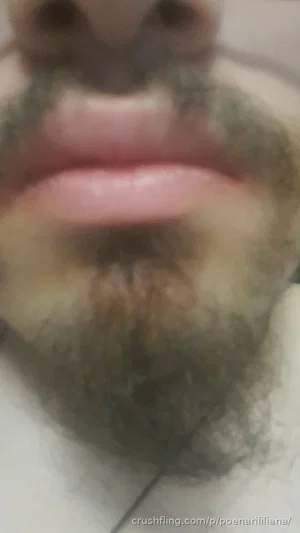 Close-up of a man's mouth and beard, indoor setting.