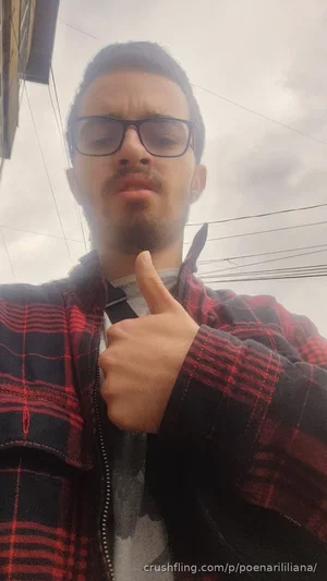 man with glasses and beard wearing plaid jacket outdoors, giving thumbs up