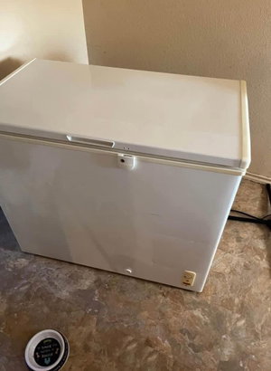 White chest freezer on tiled floor indoors.