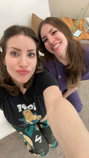 Two women in pajamas taking a selfie indoors.