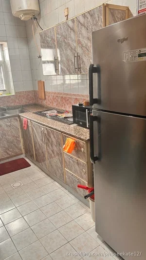 Kitchen with stainless steel fridge, marble cabinets, and tiled floor.