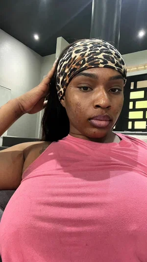 Woman with leopard print headband and pink top, indoors, posing for selfie.