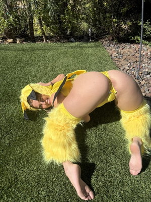 Woman in yellow costume posing on grass outdoors.
