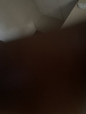 Blurry dark corner of tiled indoor room.