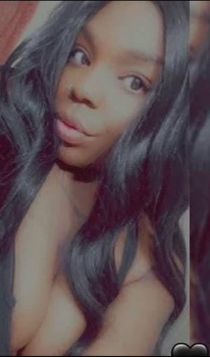 Woman with long dark hair, bare shoulders, indoor selfie.