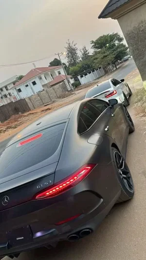 Black Mercedes GT 53 parked on a residential street with another car behind it.