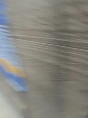 Blurred image with indistinct shapes and colors, no clear person or setting visible.