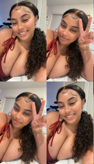 Curvy woman with curly hair in red top, peace sign, bedroom.