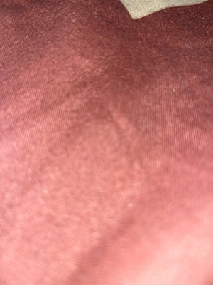 Close-up of textured pink fabric, possibly clothing or bedding.