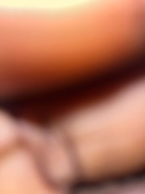 Blurred close-up of skin tones, possibly legs or torso, indistinct setting.