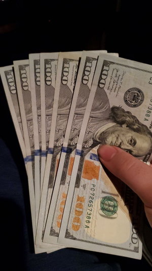 Hand holding fanned $100 bills.