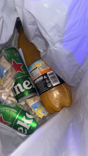 Bag of Heineken beers, orange soda, snacks.