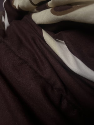 Close-up of wrinkled dark brown patterned fabric.