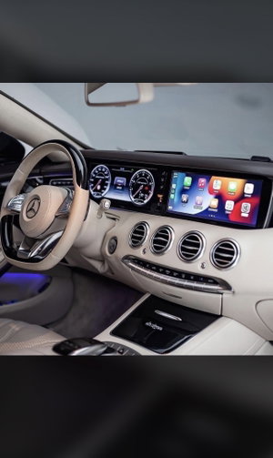 Luxury Mercedes car interior with beige dashboard and touchscreen.