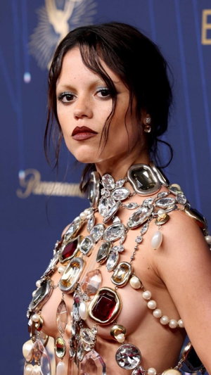 Dark-haired woman in jeweled top at indoor event.