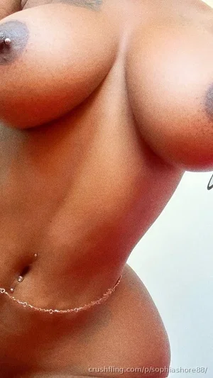 Woman with bare breasts and navel piercing, close-up torso shot.
