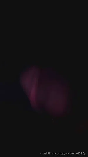 Blurry dark image with indistinct pinkish shape, no clear person or setting.