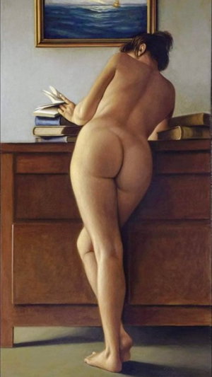 Nude woman leaning over wooden dresser reading book indoors.