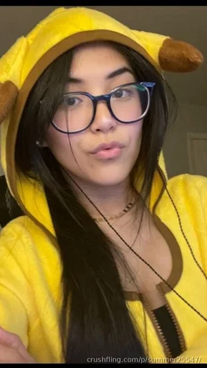 Woman in yellow banana hoodie with glasses, indoors, making a playful face.