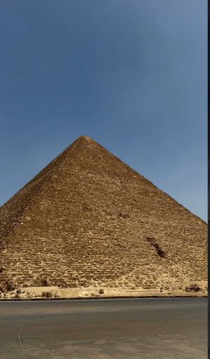 Ancient pyramid under clear blue sky in desert.