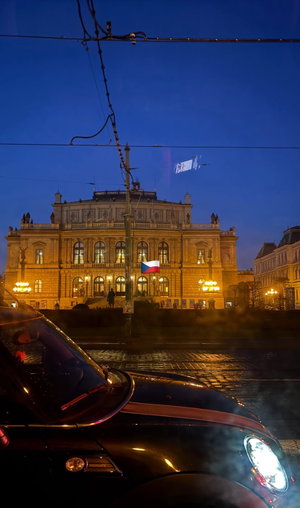 Historic building illuminated at night with car in foreground