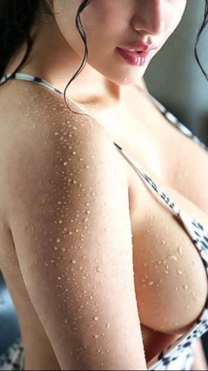 Curvy woman with dark hair in zebra bikini top, wet skin.