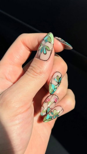 Hand with floral nail art designs.
