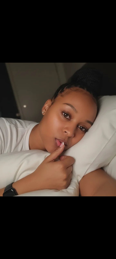 Woman in white t-shirt lying in bed.