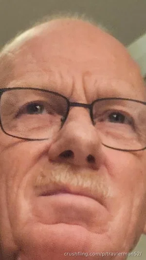 Close-up of an older man with glasses and a mustache, indoors.