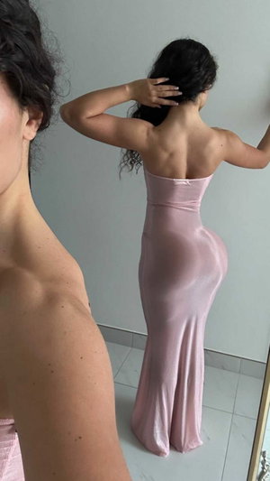 Woman in pink strapless dress, back view, mirror selfie, indoor setting.