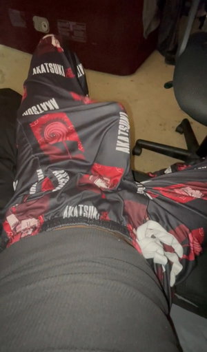 Person in gray pants and patterned pants lying on floor, indoor setting.