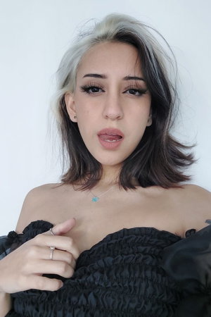 Woman with two-tone hair in black off-shoulder top.