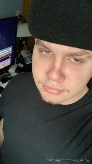 Man in black beanie and t-shirt, indoor setting, looking at camera.