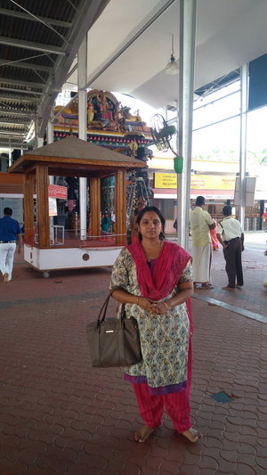 Indian woman in traditional attire standing at temple entrance.