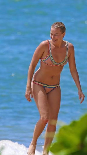 Woman in colorful bikini standing in ocean water.