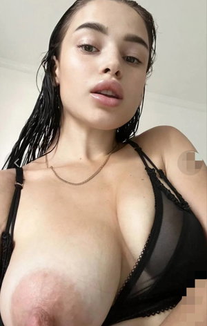 Woman with wet hair in black lace lingerie, indoor selfie.