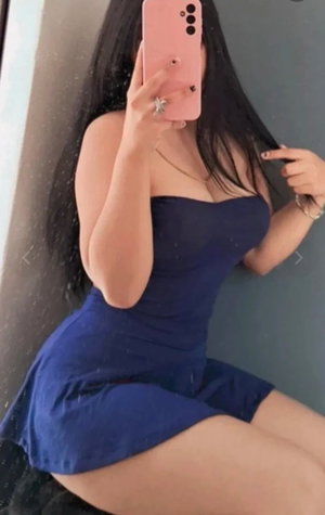 Woman with long black hair in blue strapless dress taking selfie.