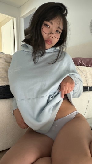 Curvy Asian woman in cropped hoodie and panties on bed.