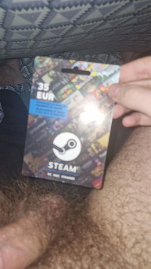 Hand holding Steam gift card over hairy leg.
