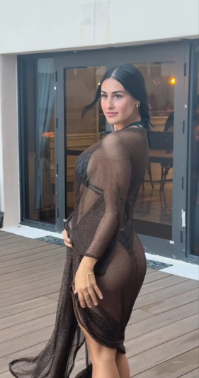 Woman in sheer sparkly dress on wooden deck.