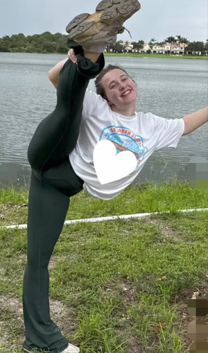athletic woman in black leggings stretching outdoors by lake